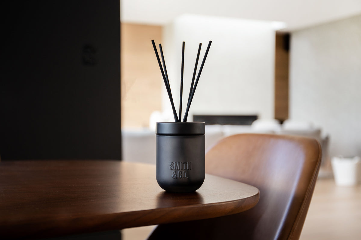 Smith & Co. diffuser on a timber dining table with a chair, open-plan room behind