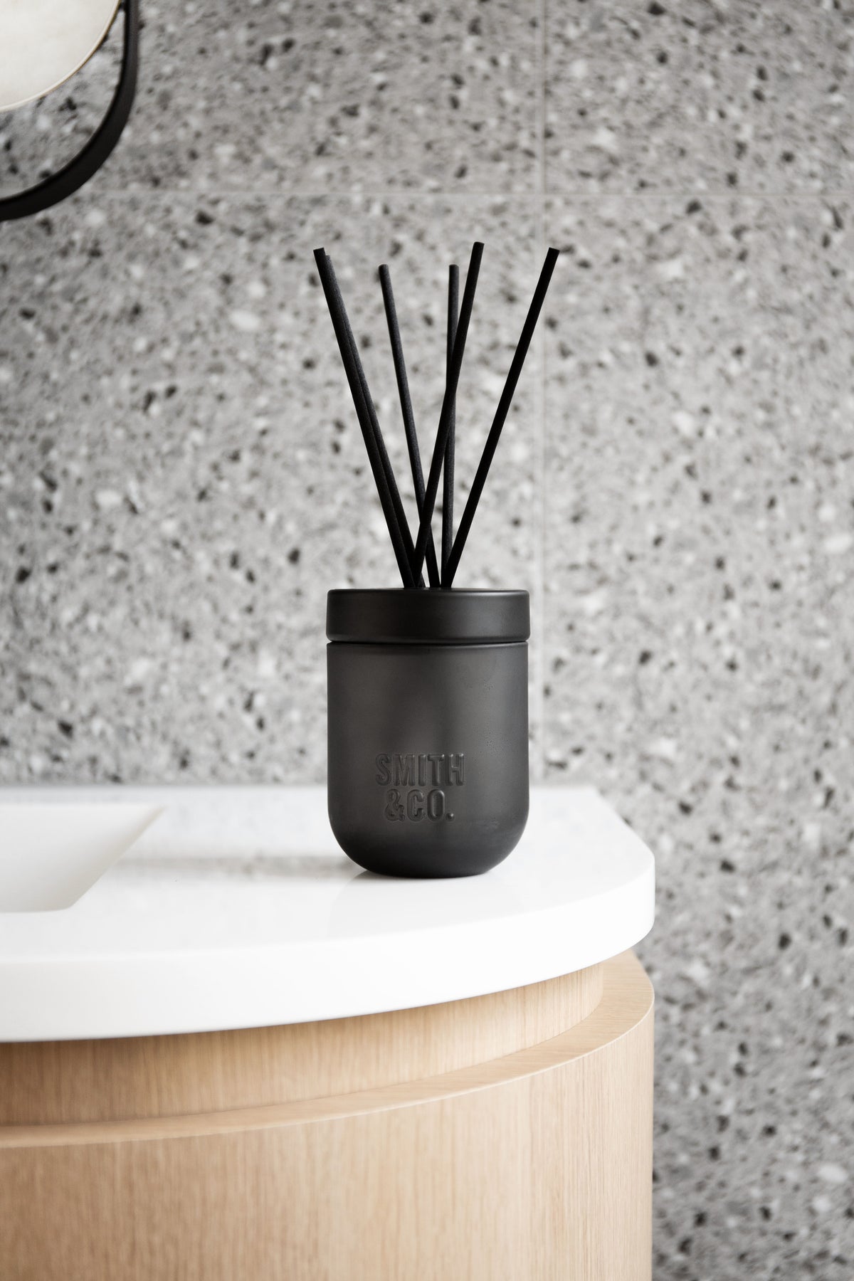 Smith & Co. diffuser on a white curved vanity against terrazzo