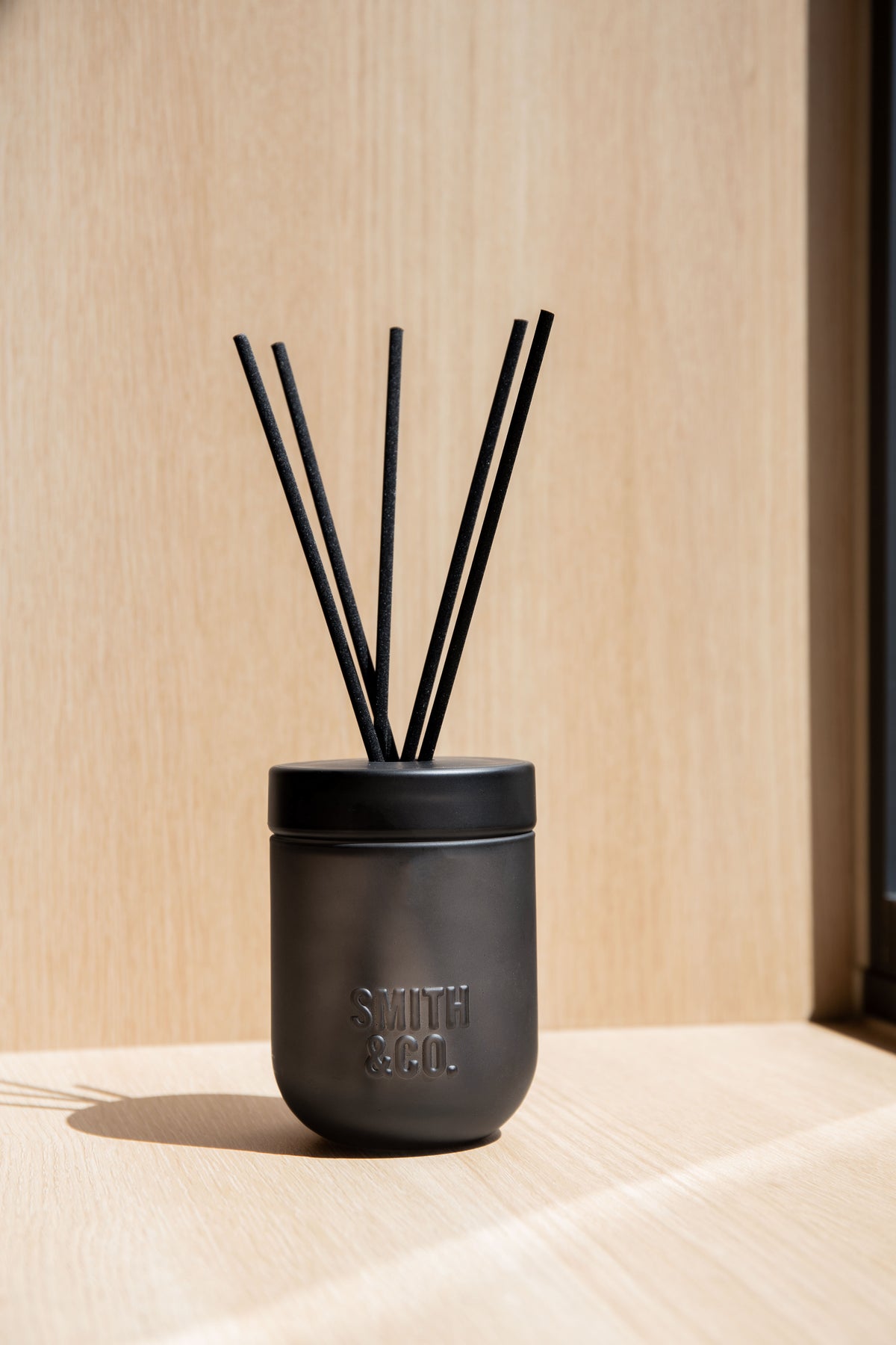 Smith & Co. diffuser on a pale shelf against a warm timber wall