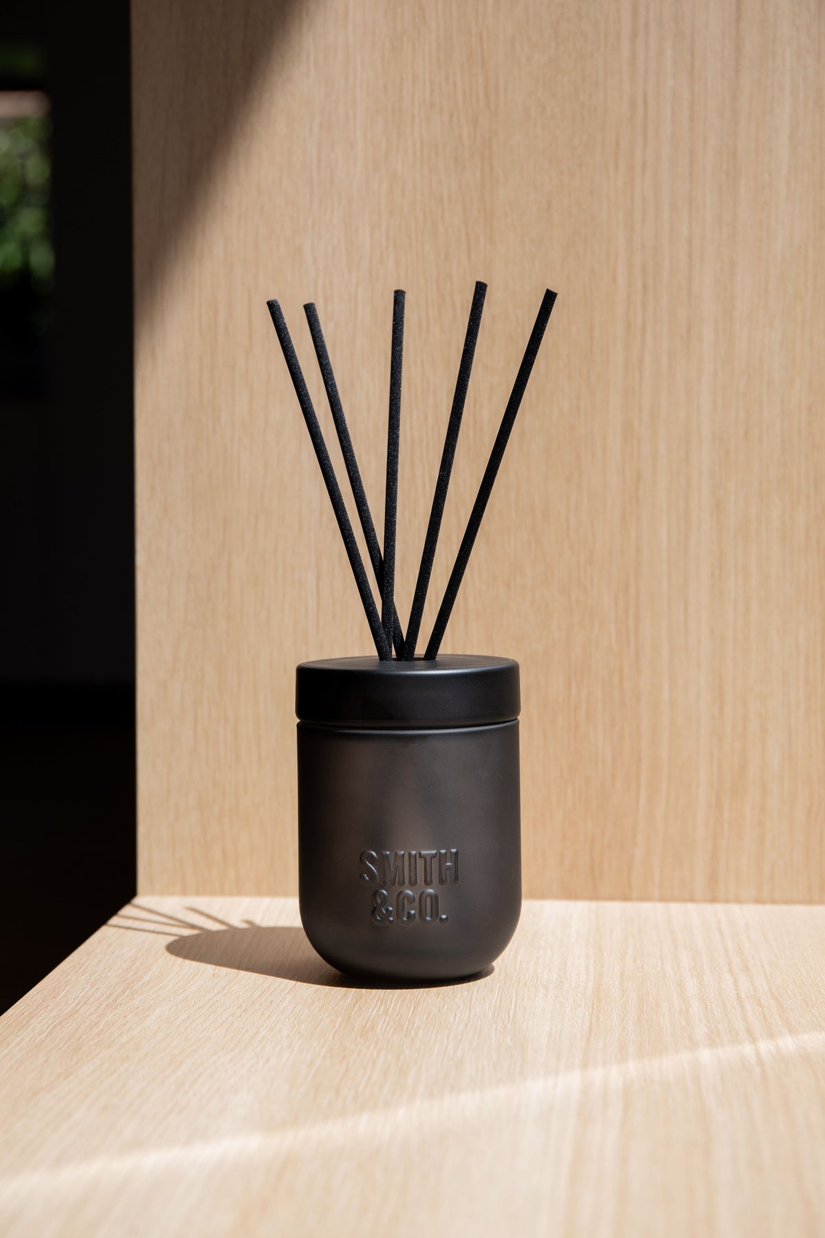 Smith & Co. diffuser on a pale ledge in front of timber wall panelling