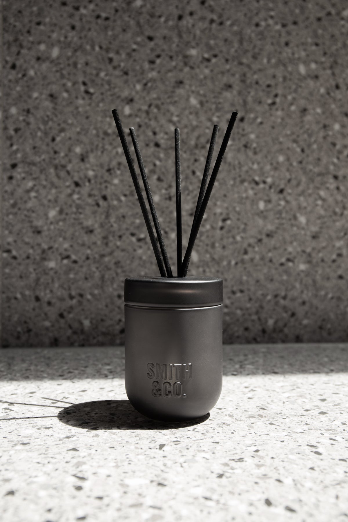 Smith & Co. diffuser on a terrazzo ledge against a matching terrazzo wall