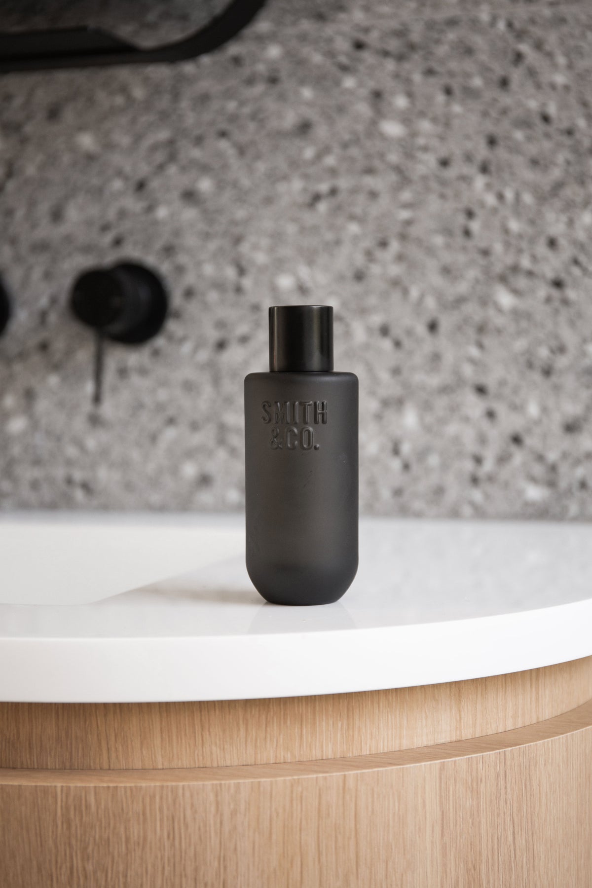 Black Smith and Co room spray on a round white basin above a timber vanity