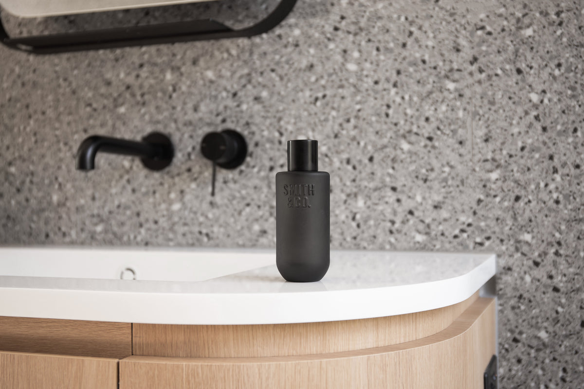 Wide view of the black Smith and Co room spray on a vanity with black tapware