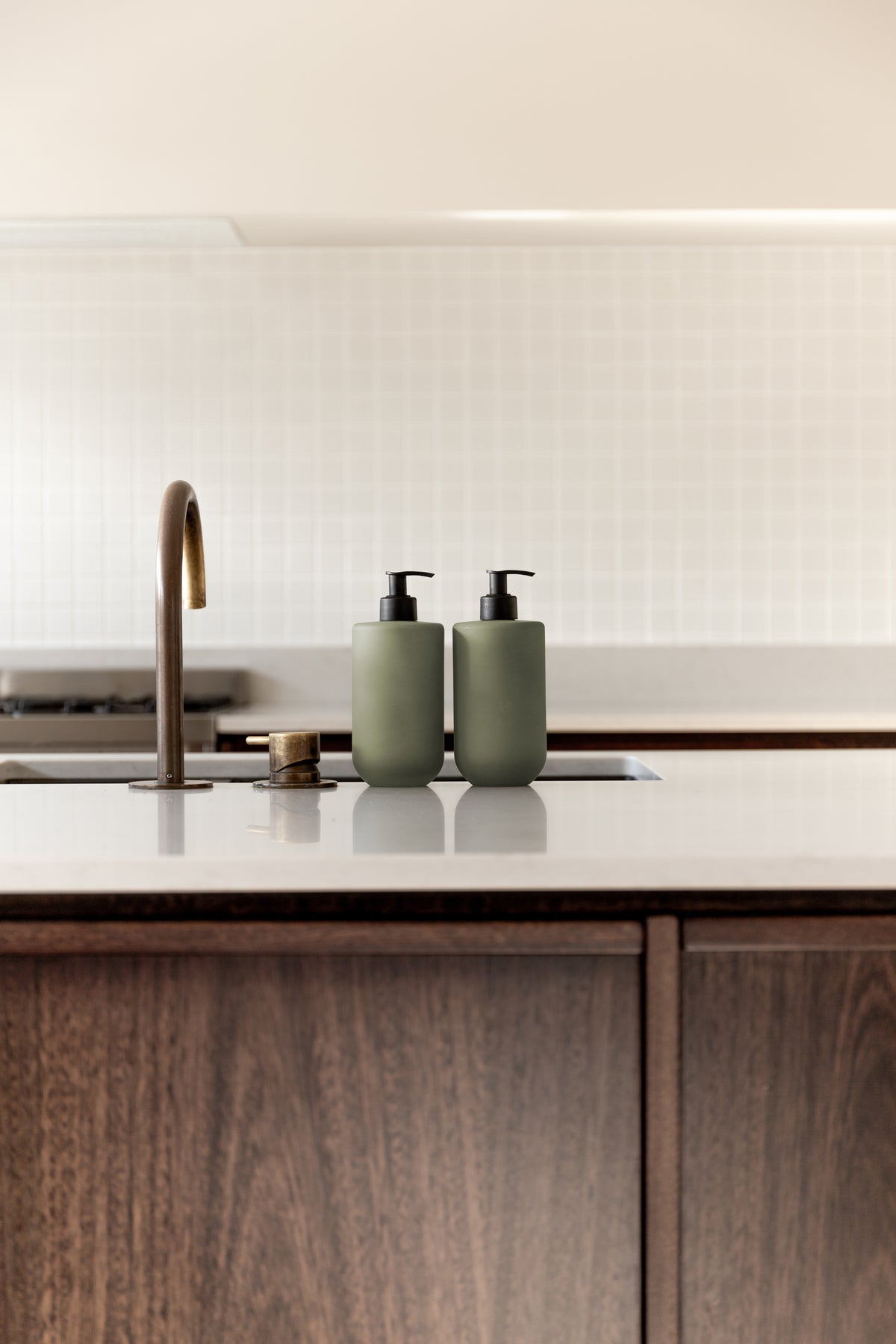 Kitchen island and white benchtop with Smith & Co. bottles near the tap