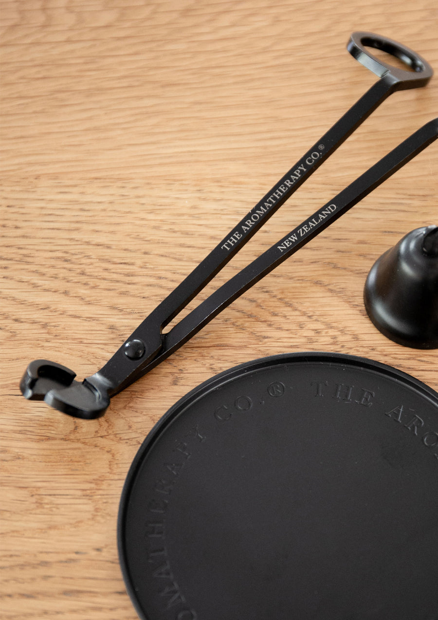 Close view of the trimmer's engraved arms above a round embossed black plate on light oak