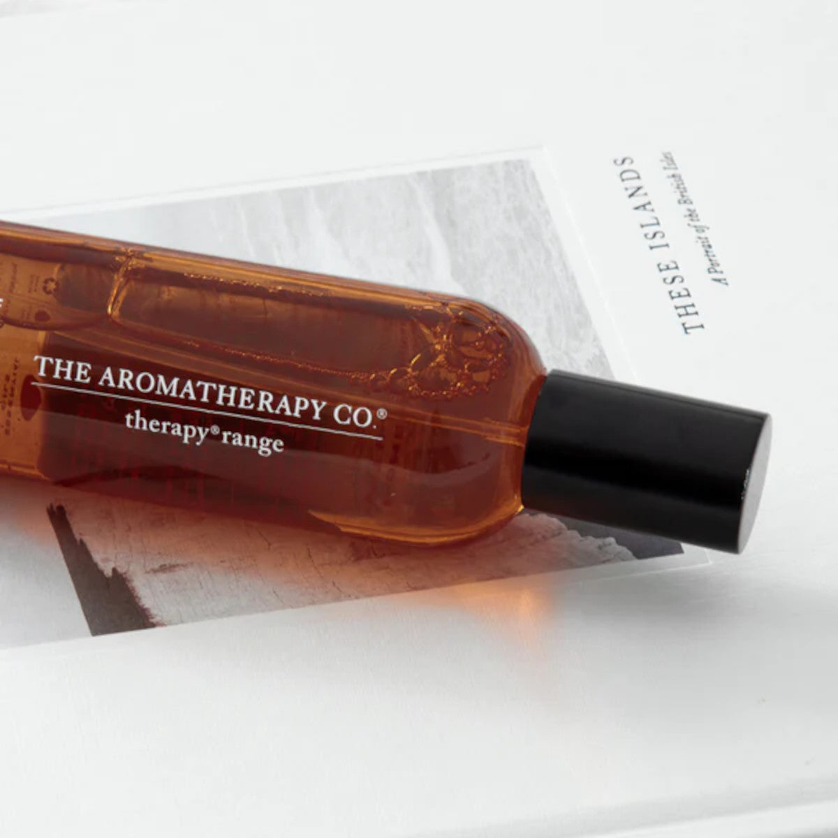 Landscape close up of the amber spray bottle resting across an open book