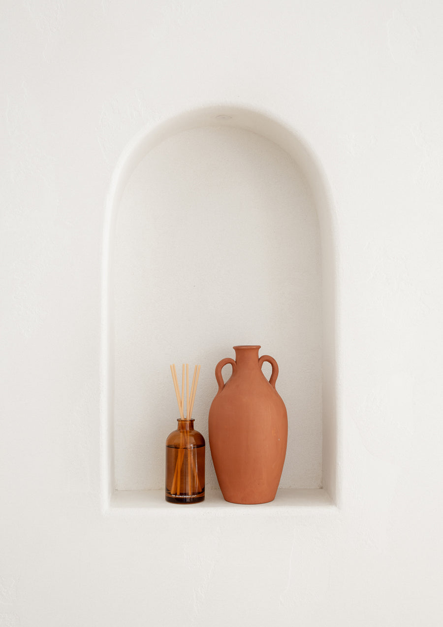 Terracotta vases in a white arched wall niche