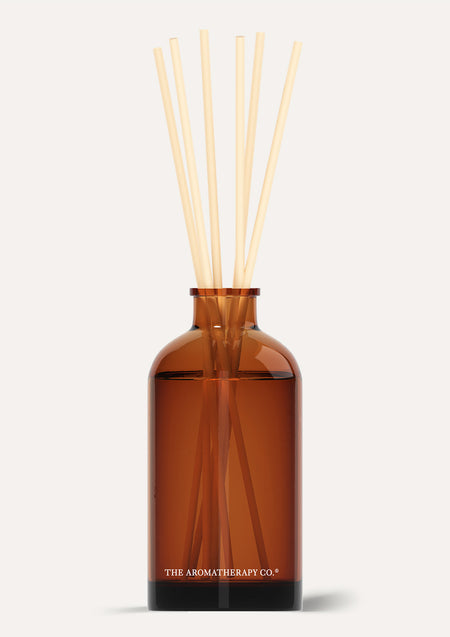 Amber Therapy reed diffuser with natural reeds on a warm off-white background with a soft shadow