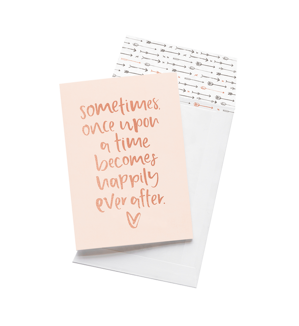 Once Upon A Time card in blush with rose gold script and an arrow print envelope, on grey