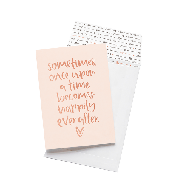 Once Upon A Time card in blush with rose gold script and an arrow print envelope, on grey