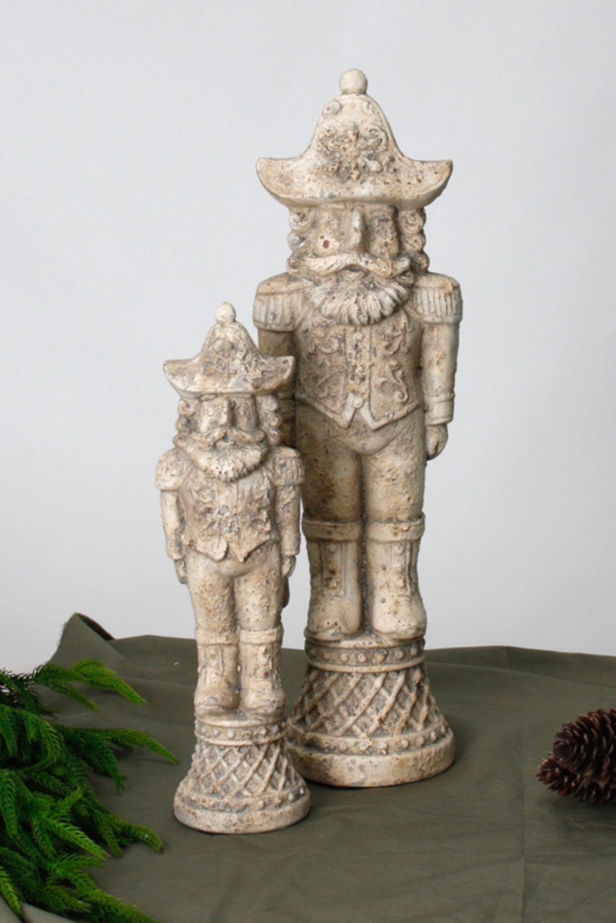 Stone-look nutcracker soldiers styled on a dark surface with greenery