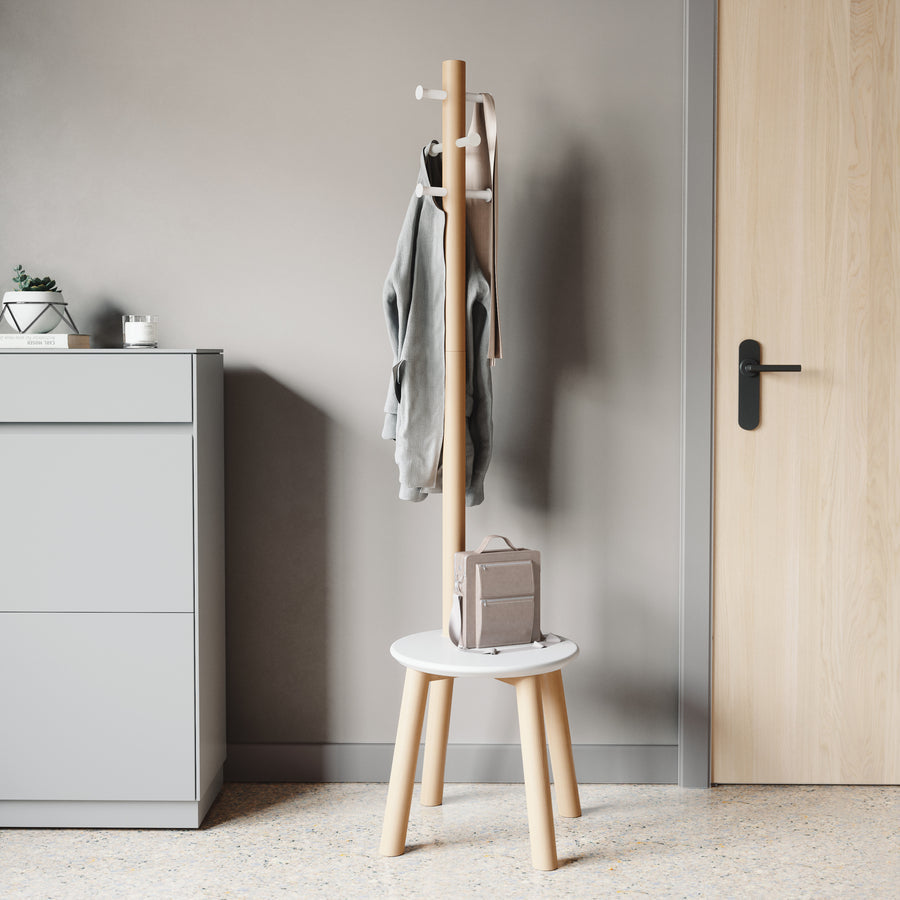 Umbra Pillar stool and coat rack in white and natural by a door, jacket on the hooks