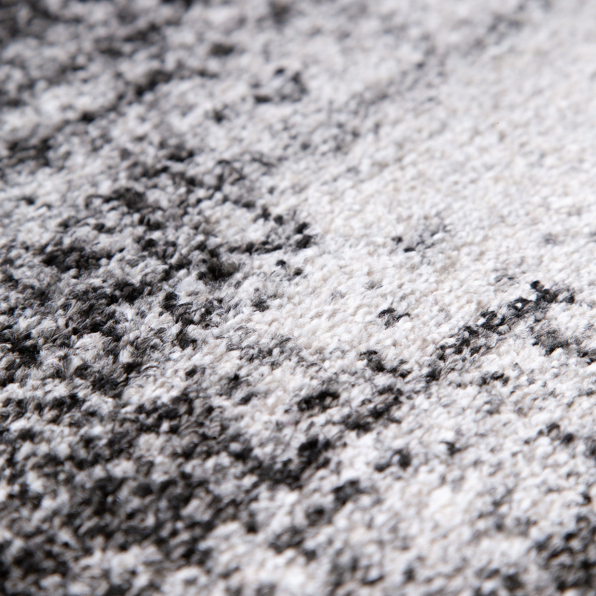Close view of the soft grey pile with black and ivory distressed markings