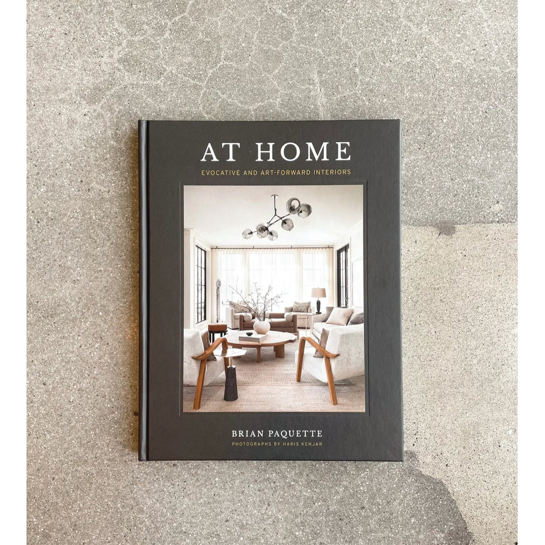 At Home by Brian Paquette hardcover lying flat on grey concrete