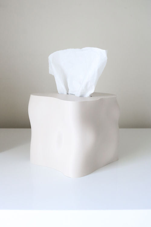 Cream Ebb tissue box cover on a white surface with a tissue drawn up through the opening