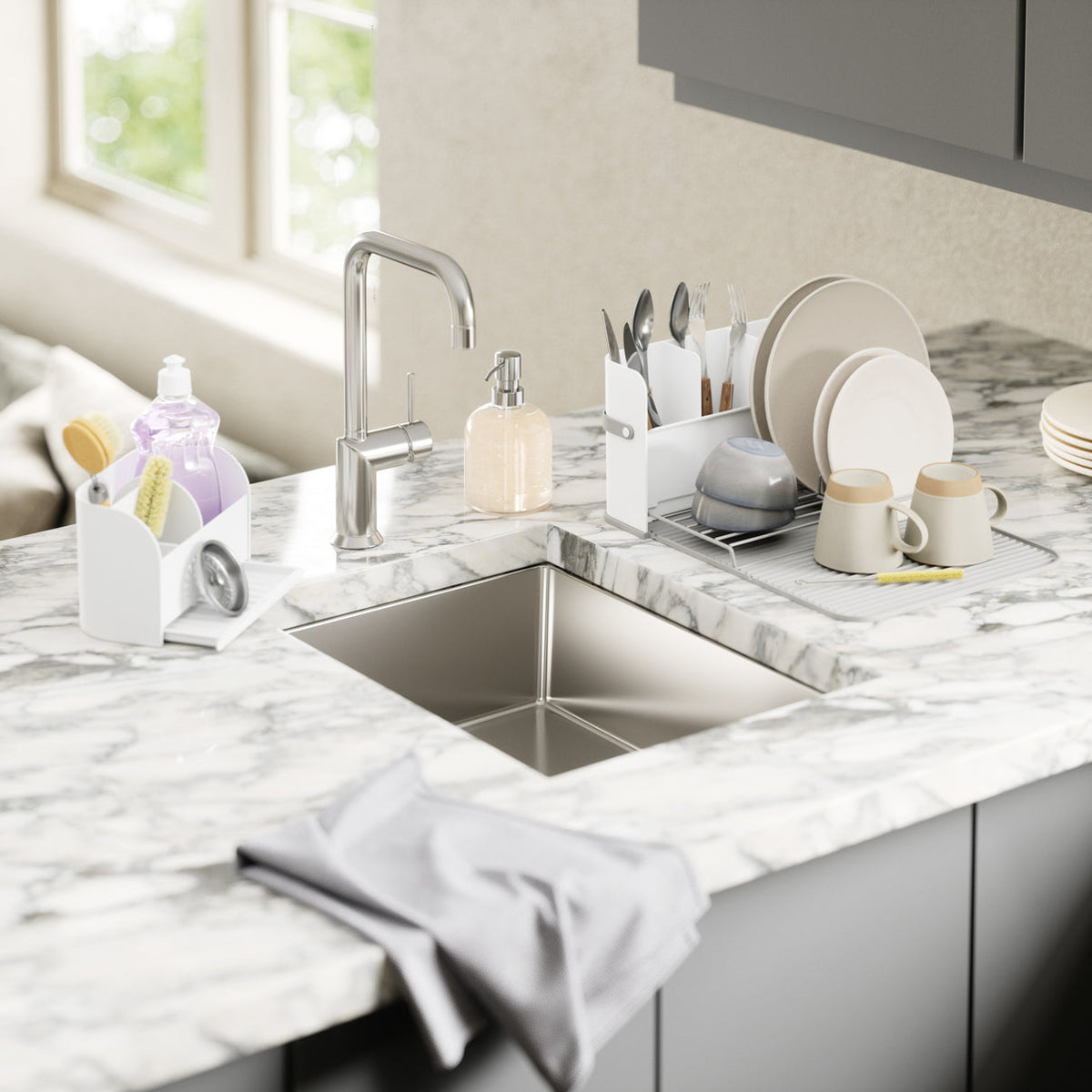 Umbra Sling sink caddy with soap pump on a marble benchtop beside the sink
