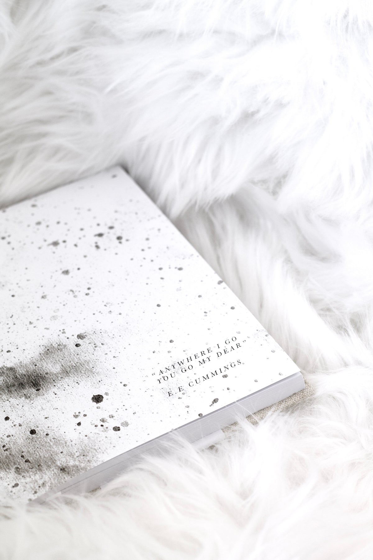 Bump journal endpapers with speckled watercolour artwork and a quote, on white faux fur