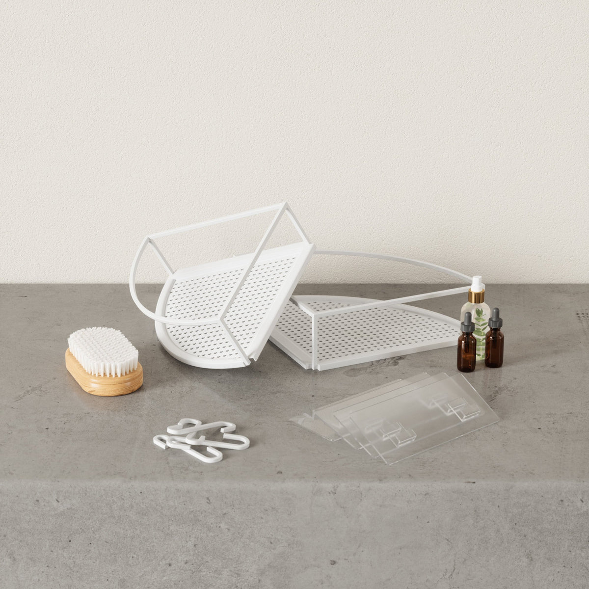 White Cubiko corner bin on a benchtop beside its hooks and adhesive strips