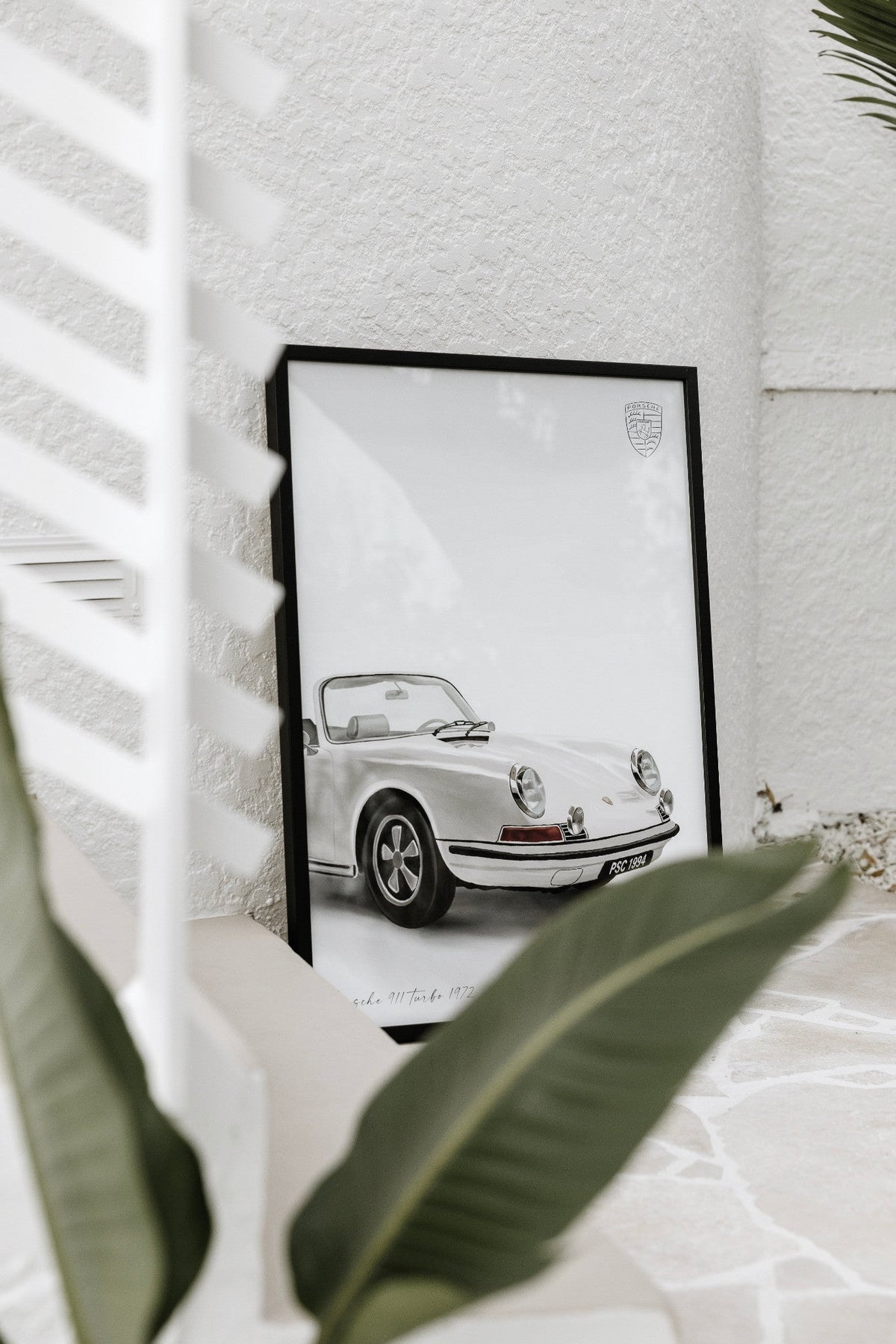 Framed classic open-top sports car print by Papier HQ in a styled room
