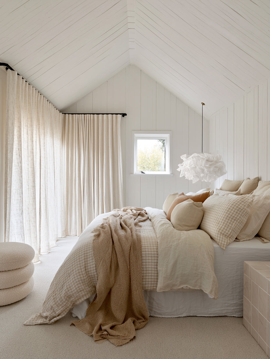 White Cloud Pendant paper lamp shade above layered neutral bedding in a calm Scandi bedroom