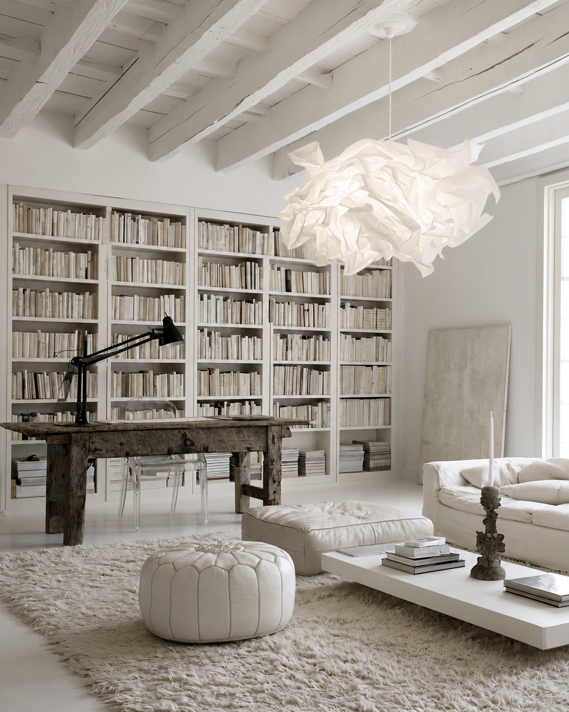 White Cloud Pendant paper lamp shade in a light living room with built-in bookshelves and a white pouf