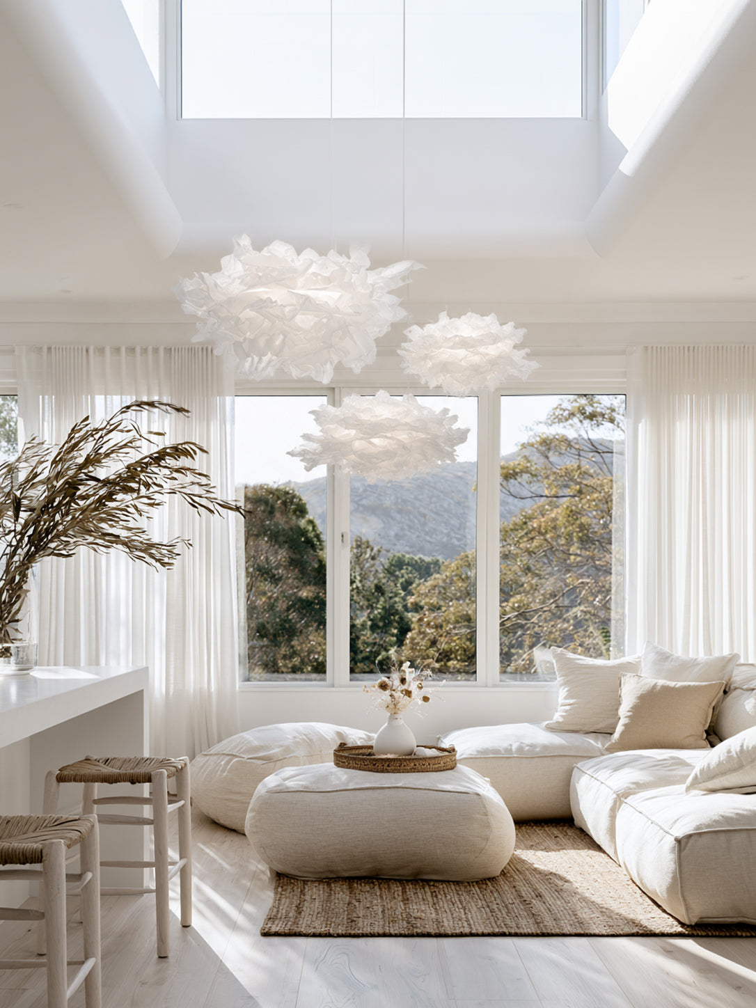 White Cloud Pendant paper lamp shade in a bright coastal living room with cream sofa and olive branches