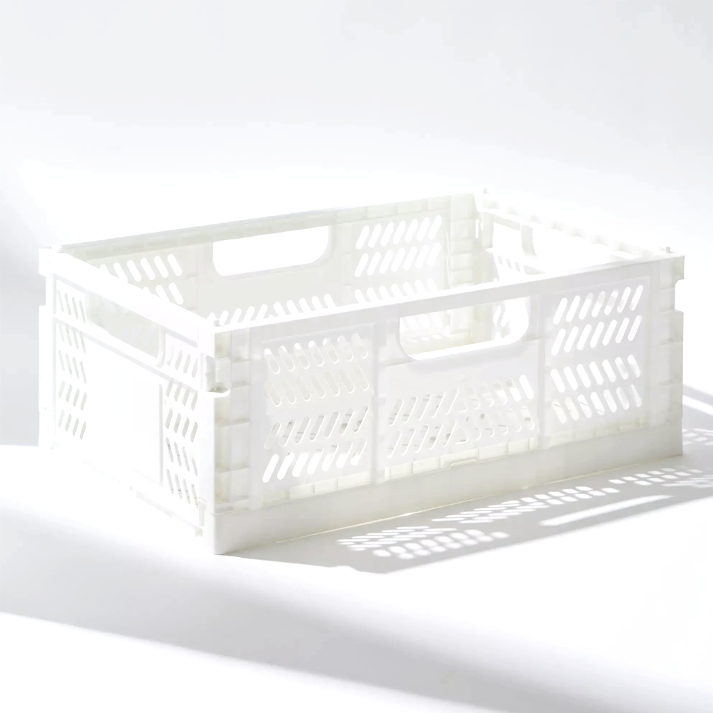 White folding crate assembled on a pale surface, side panels locked upright