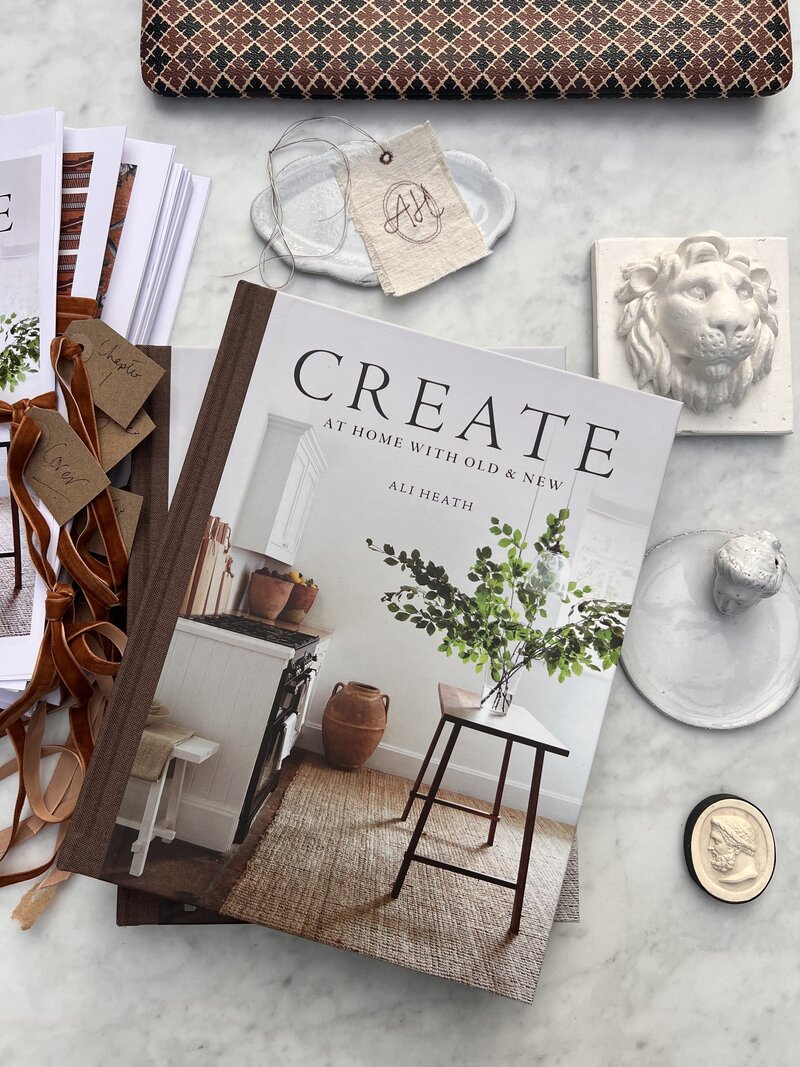 Create - a collection of CREATE: AT HOME WITH OLD & NEW books and accessories on a marble table.