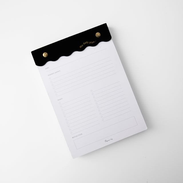 Black curved daily notes pad with gold edged pages and linen header