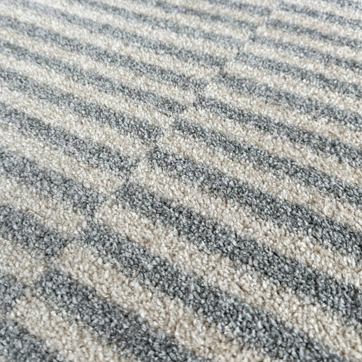 Close view of the short pile showing the offset cream and grey stripes