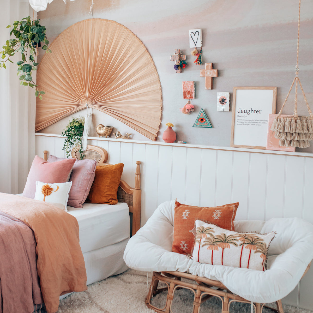 Daughter print in a natural frame on a panelled wall in a girl's bedroom with a rattan chair