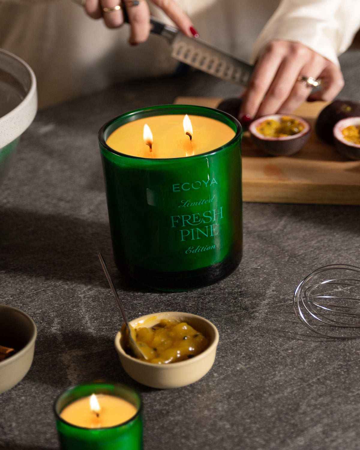 Lit Ecoya Fresh Pine Grand Madison candle on a dark stone kitchen bench