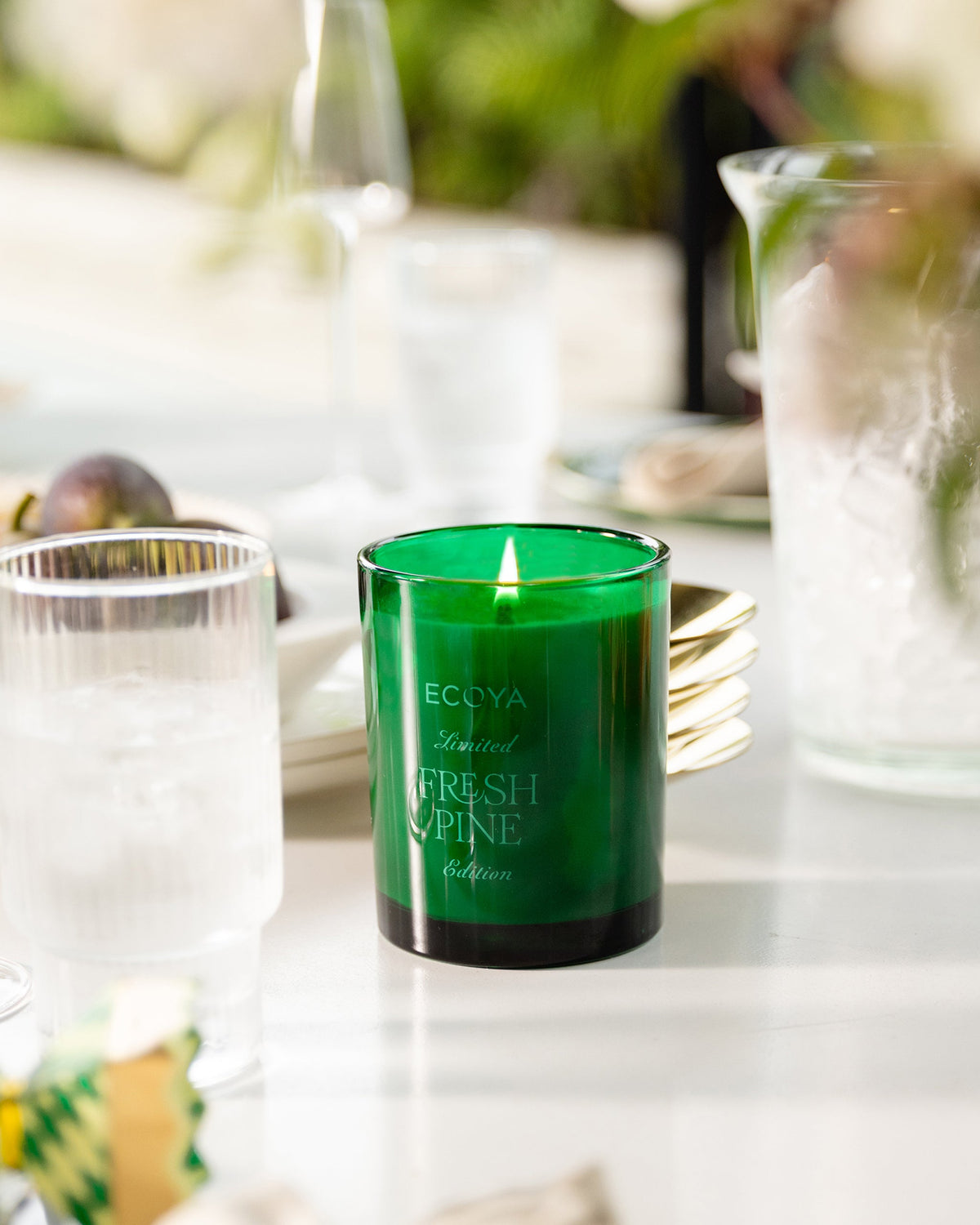 Ecoya Fresh Pine Madison candle lit on a set dining table with glassware