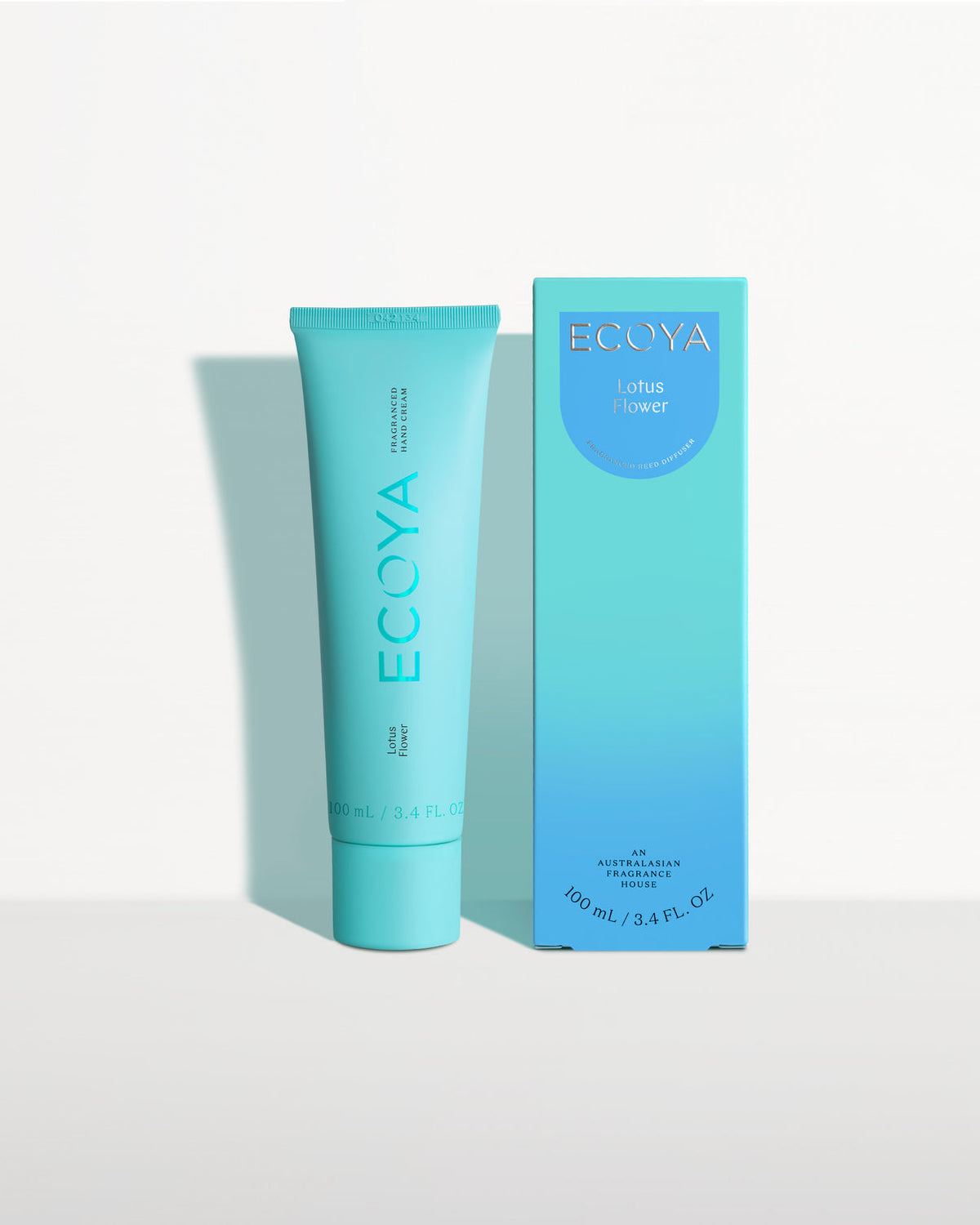 Ecoya hand cream in a teal tube beside its teal gradient box
