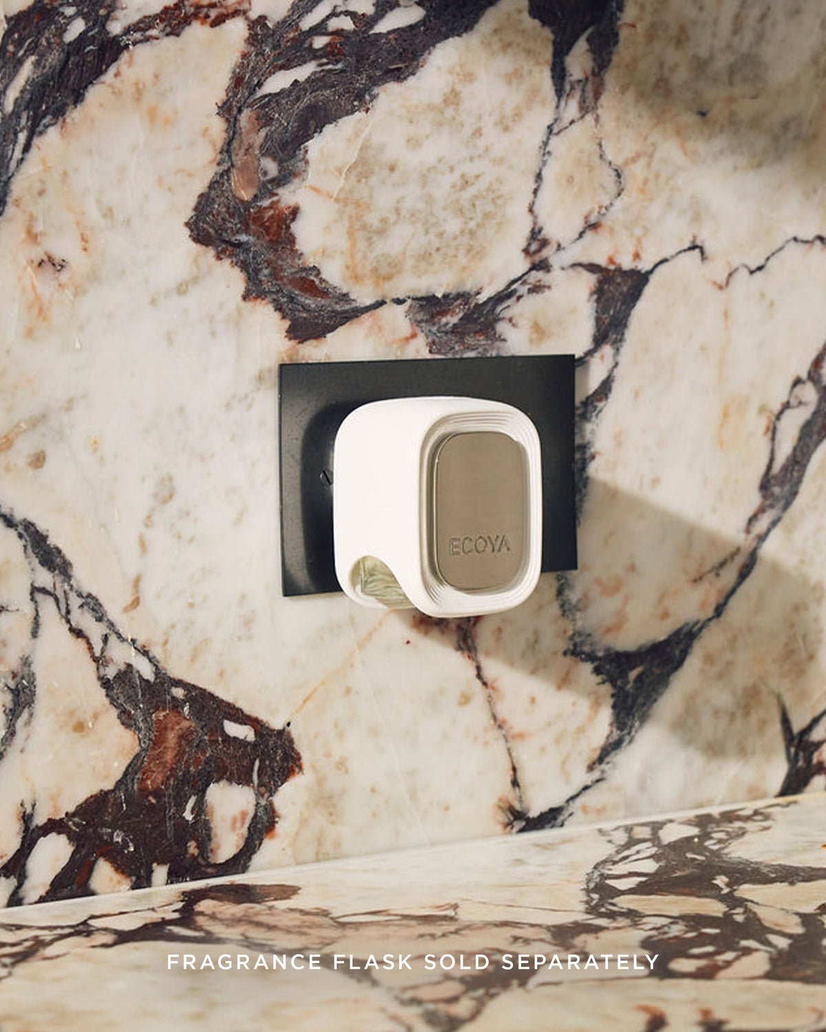 Ecoya Plug-In Diffuser plugged into a wall socket on a marble wall