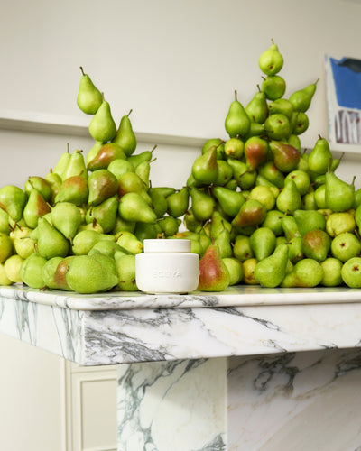 ECOYA Electric Wax Melter on a marble surface styled with green pears referencing the French Pear fragrance.