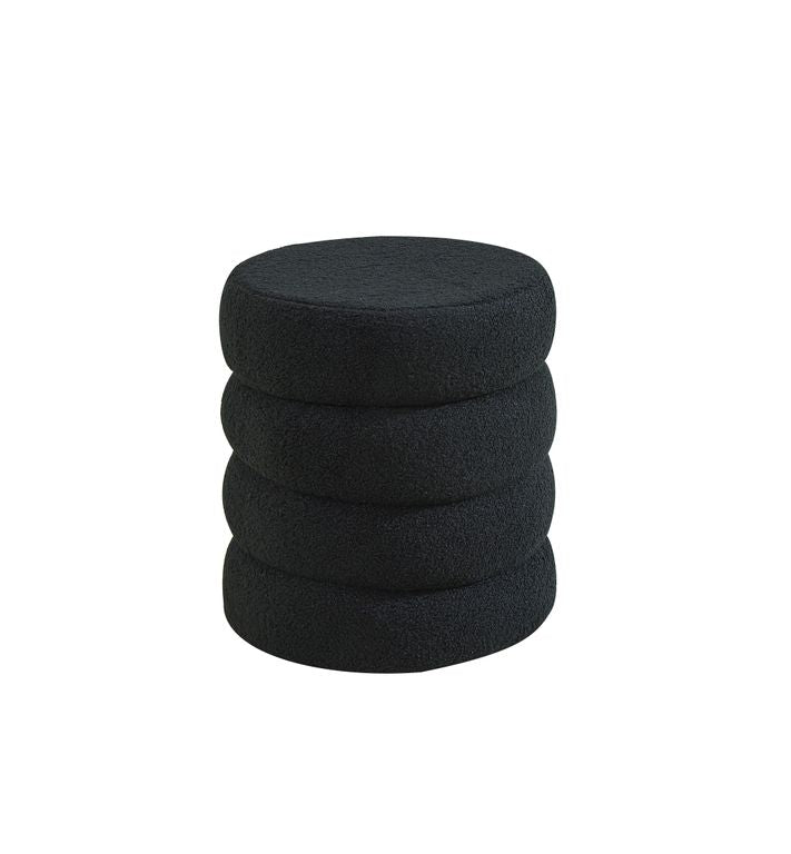 Black boucle ottoman photographed at an angle, the four tiers clearly stacked