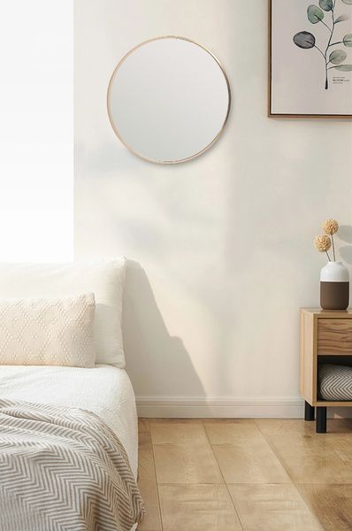 A bedroom with a white bed and the Flux Home Bella Round Wall Mirror - 60 cm - Black / Brass / Chrome.
