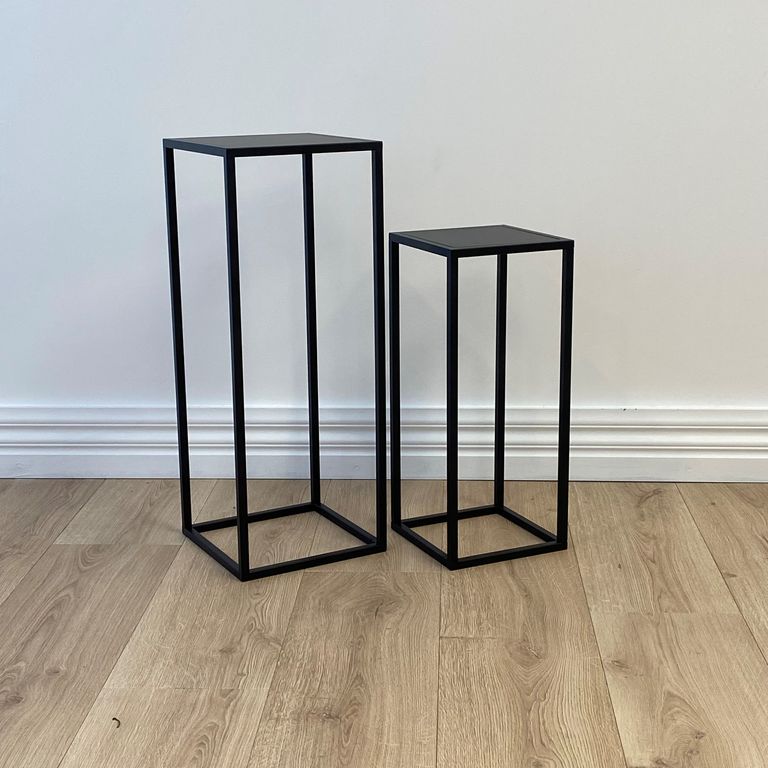 The two nesting plinths standing on timber flooring against a white wall and skirting