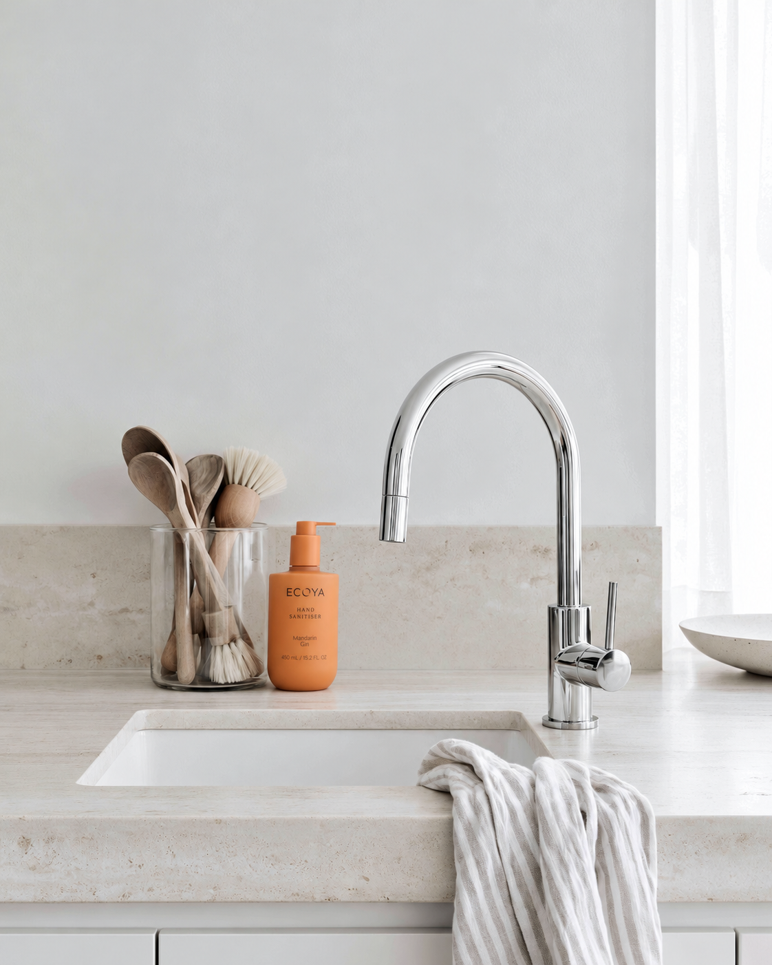 Ecoya Mandarin Gin hand sanitiser 450ml pump bottle beside a kitchen sink and chrome tap