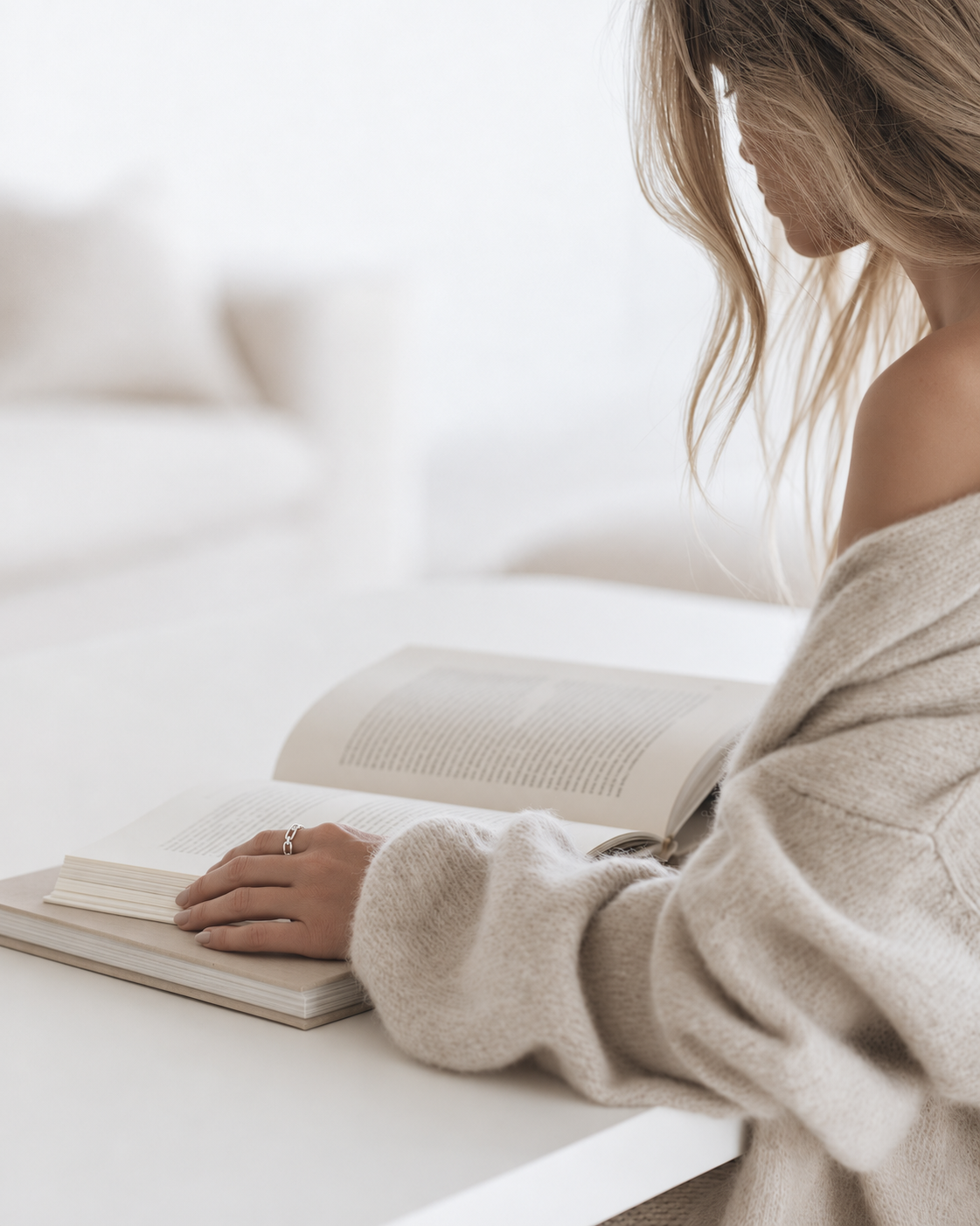 Woman reading at a white table wearing the Federation Chained Ring in sterling silver