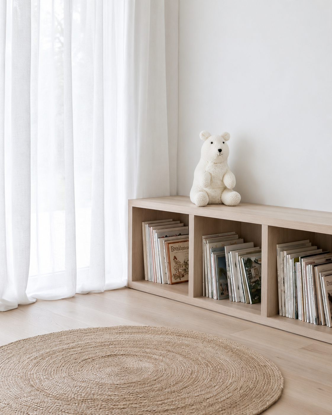 Peter the Polar Bear white soft toy by Lily & George sitting on top of a low oak book ledge