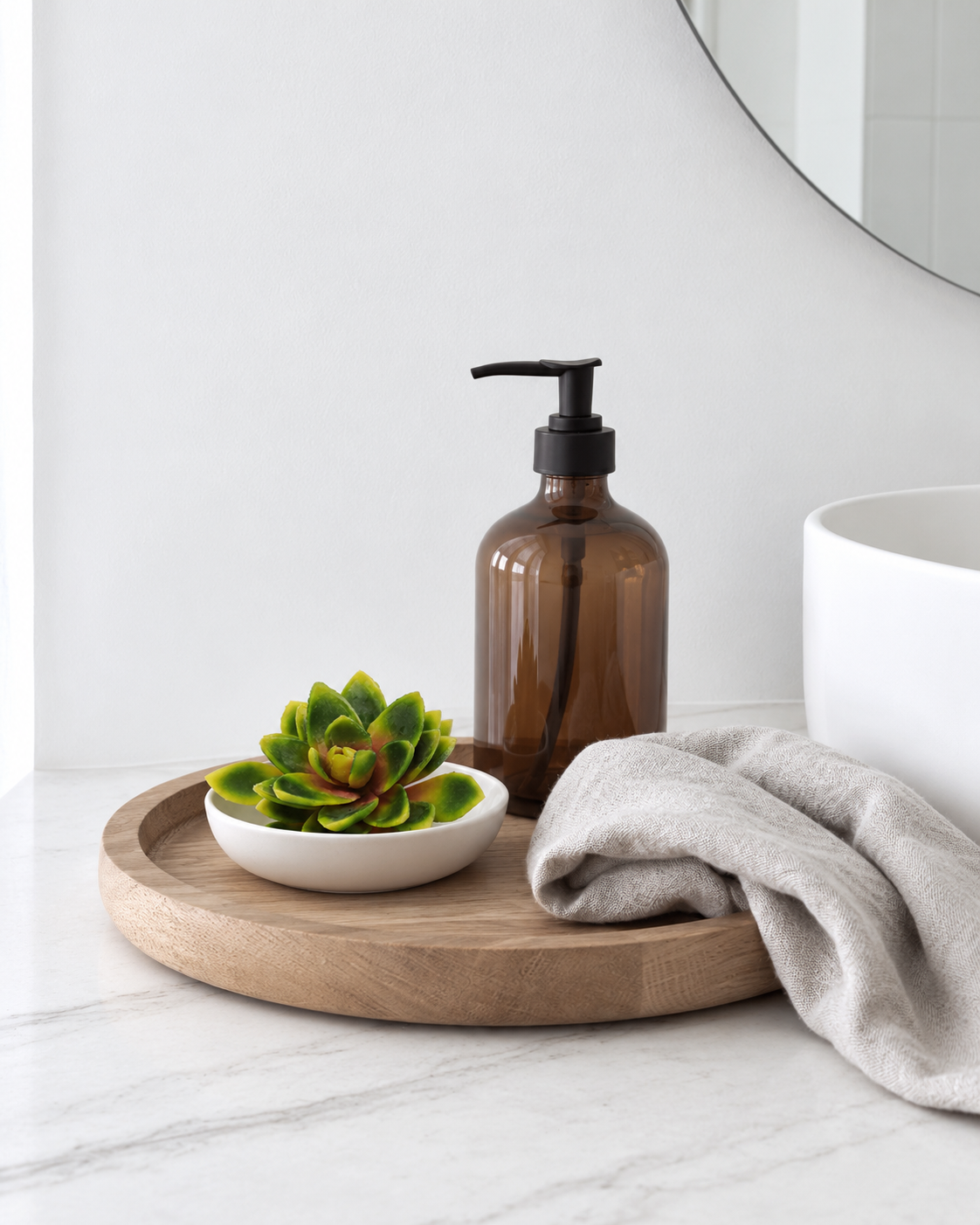 Lotus succulent pick in a small white ceramic dish on a tray beside a bathroom basin
