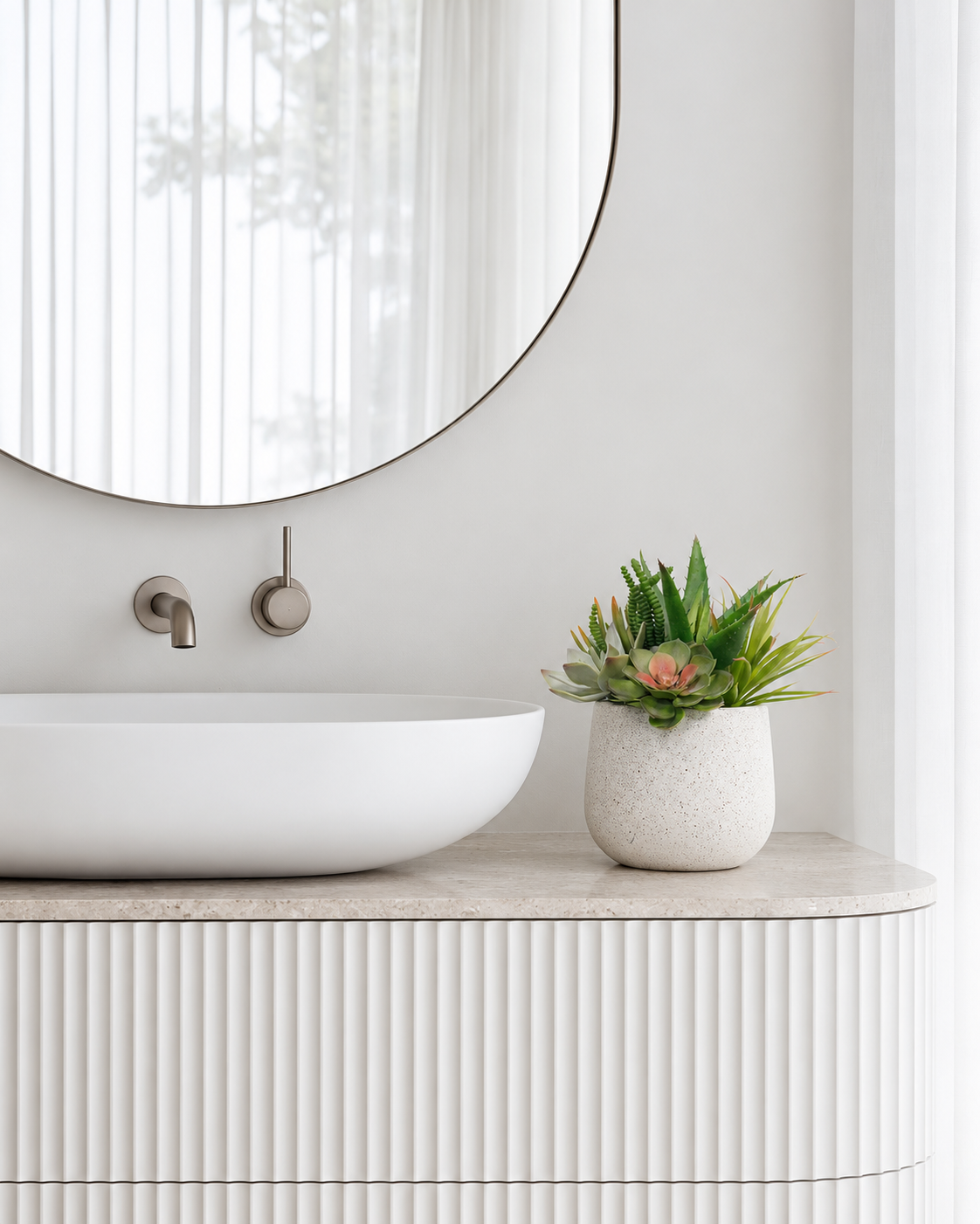 Potted aloe and succulent arrangement on a floating vanity beside the basin