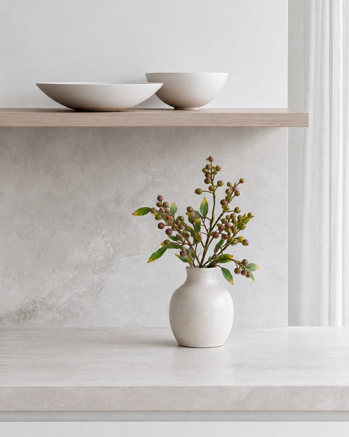 Summer Berry Branch in a white ceramic vase on the kitchen bench below the floating shelf
