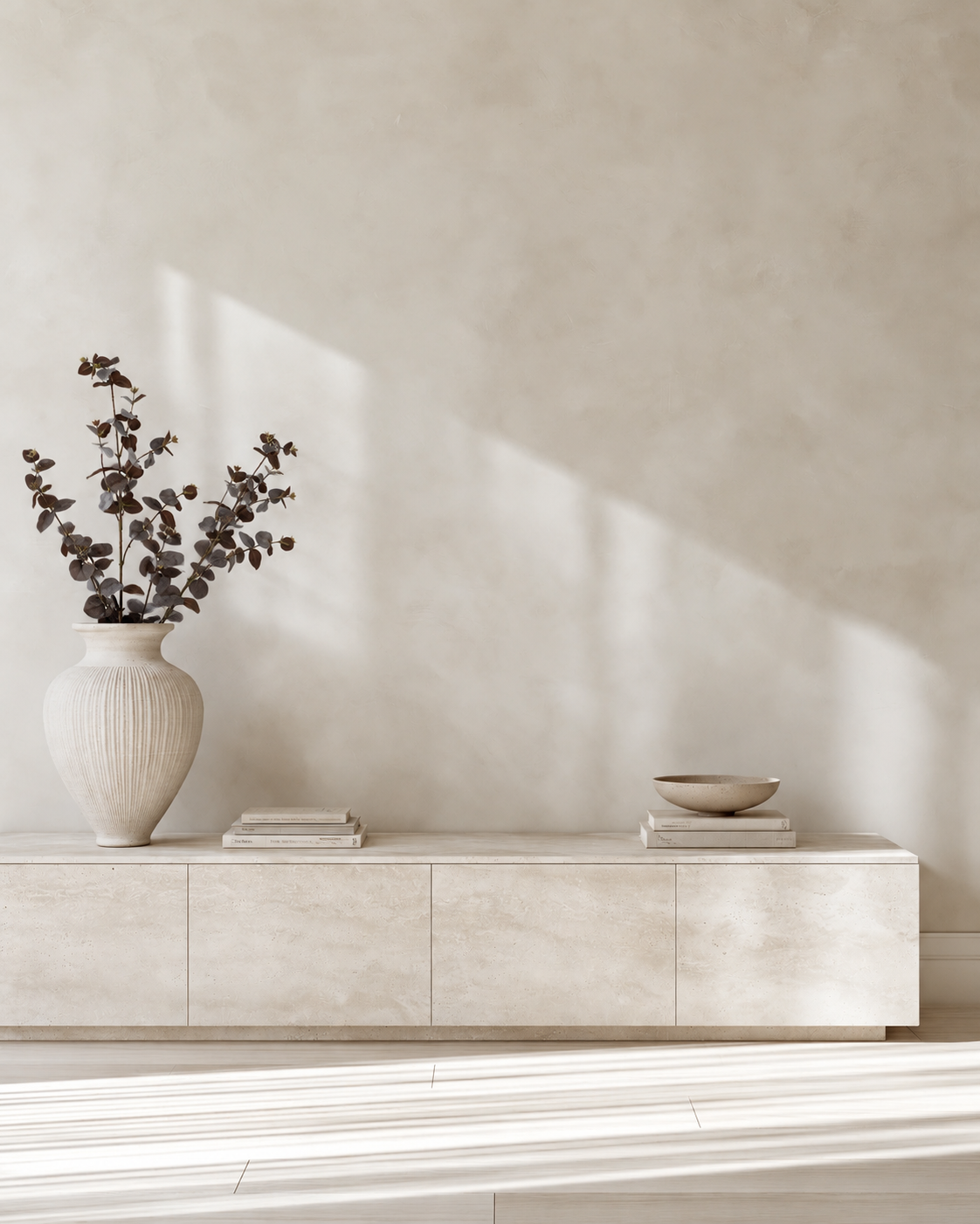 Three Large Eucalyptus stems in the ribbed vase on the travertine sideboard
