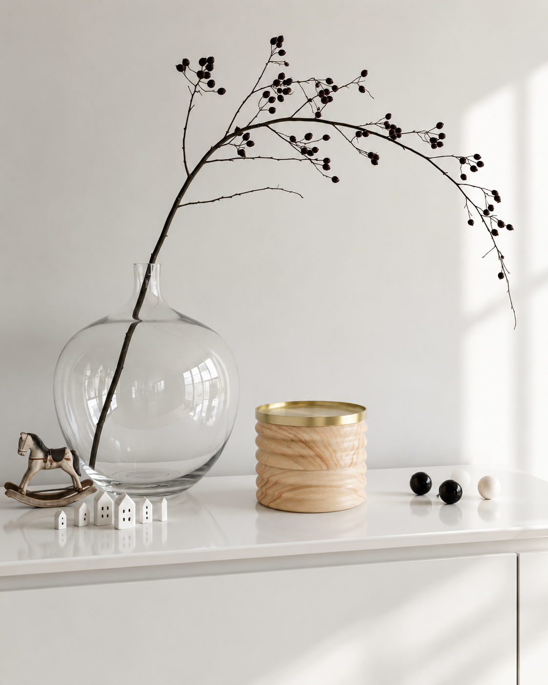 Tesora Storage Box, Natural and Brass styled on a white console beside a glass vase and branch