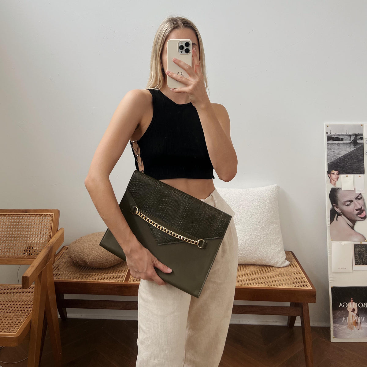 Woman holding the Forest Green laptop sleeve in a styled room