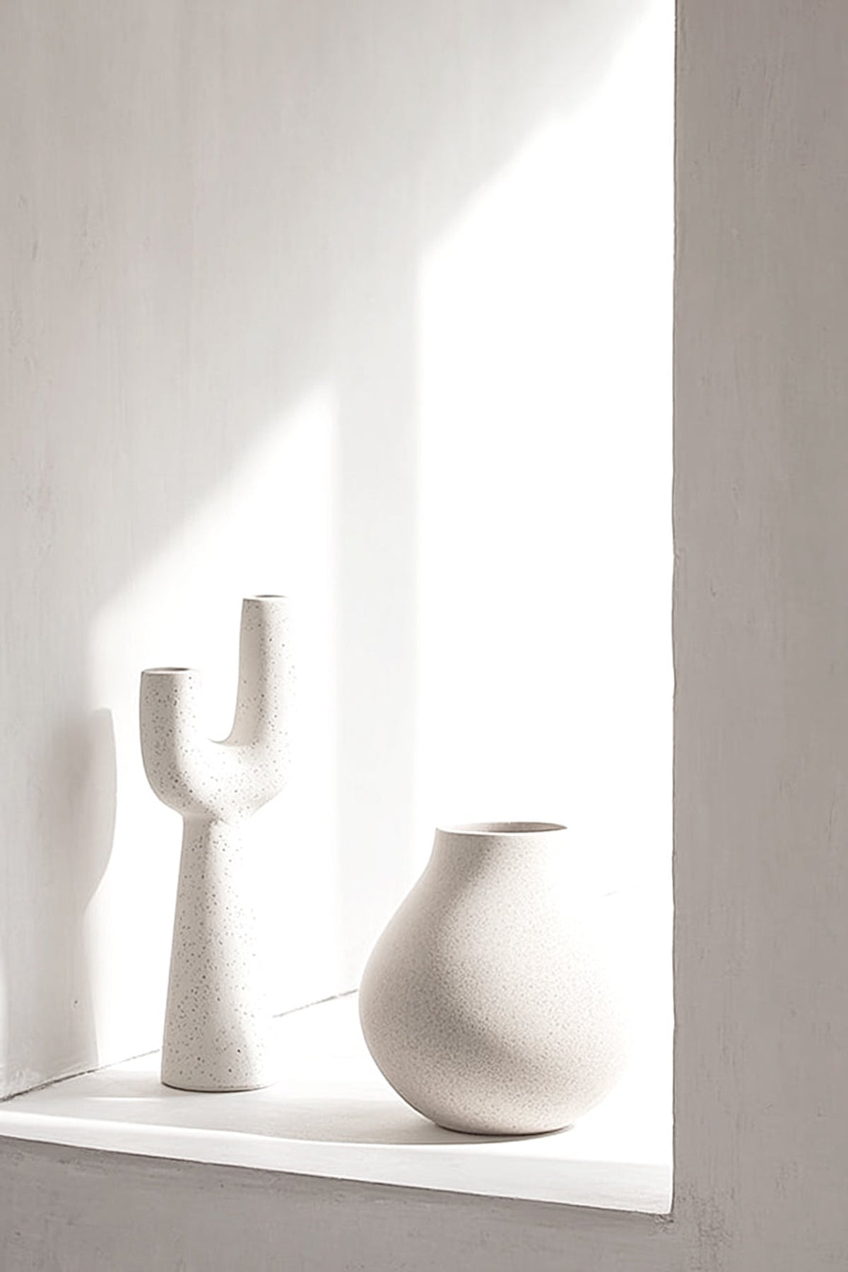 Franki vase on a sunlit white window ledge beside a round vase