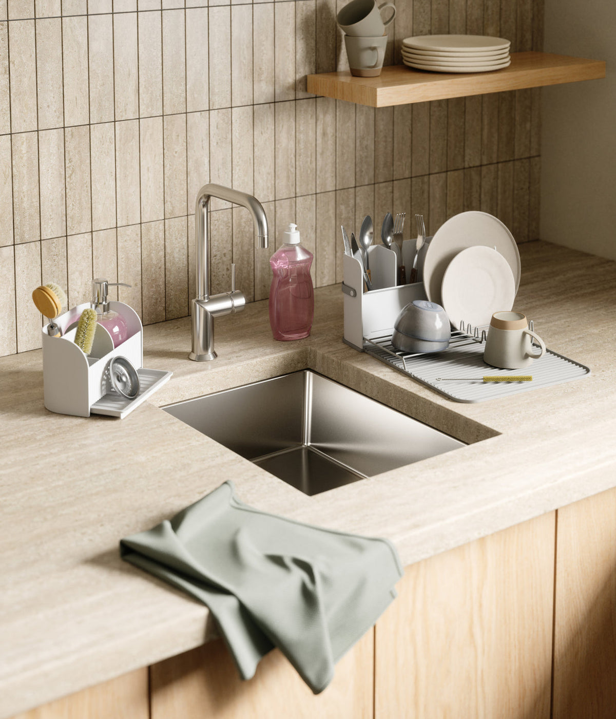 Umbra Sling dish rack beside a stainless sink with plates and utensils drying